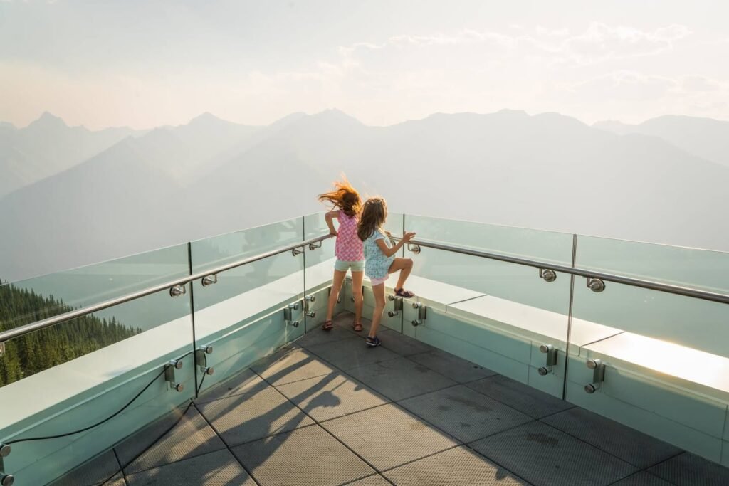 Children enjoying panoramic mountain scenery from an observation deck.