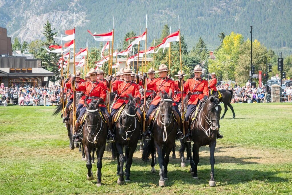 A mountie mounted on a horse in a red uniform.