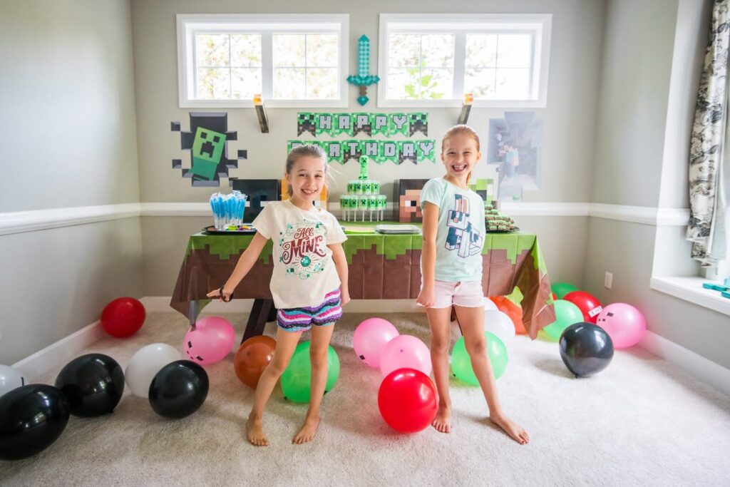 Kids at a Minecraft-themed birthday party surrounded by colorful balloons.