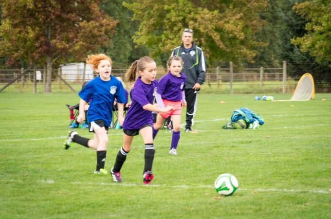Children competing in an outdoor soccer match on a crisp fall morning.