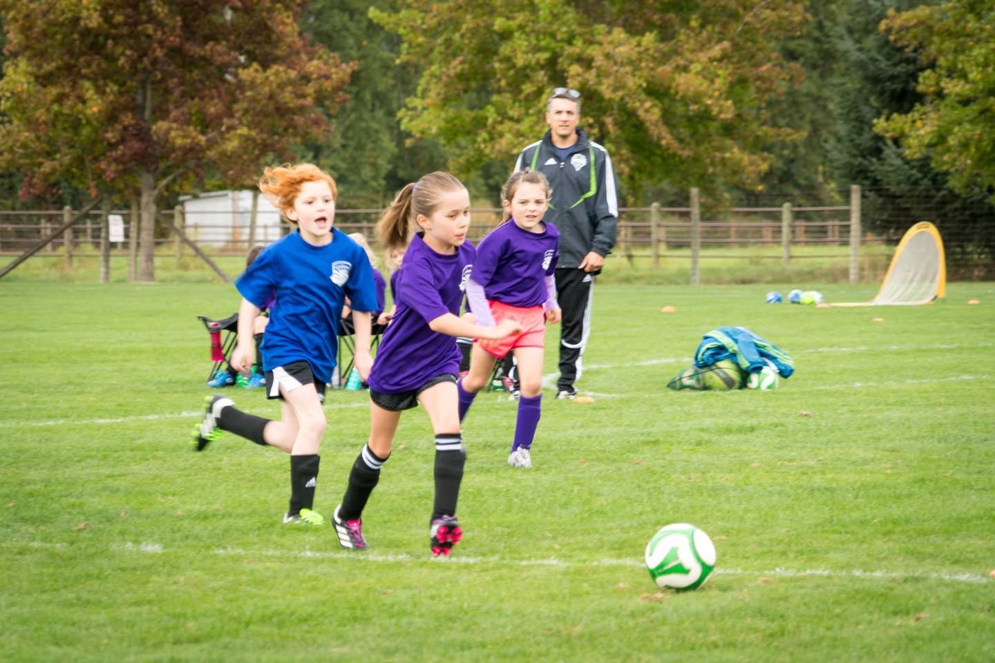 Cardinals vs. Storm Children competing in an outdoor soccer match on a crisp fall morning.