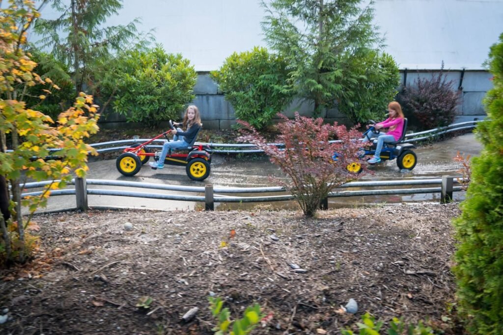Riders enjoy a scenic adventure ride track near a river with lush trees and shrubs.