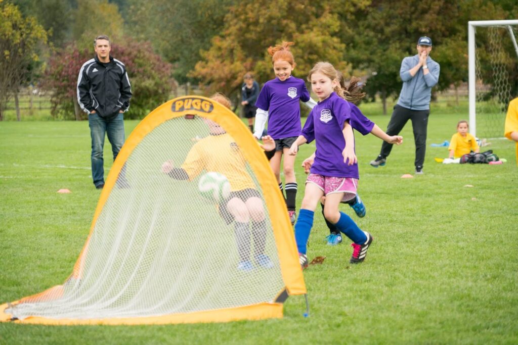 Youth soccer players in action on a spring field, showcasing local sports activities in the Pacific Northwest. The vibrant green turf reflects an active community sports environment.