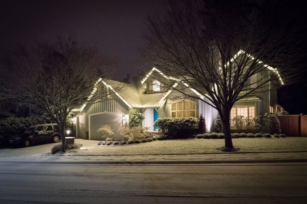 A winter evening scene with a cozy cabin nestled among bare trees, illuminated by soft, warm lights.