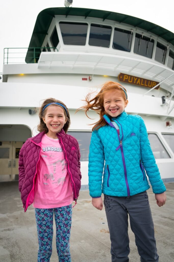 Two people smiling in front of the Puyallup ferry. A close-up of the ferry's upper deck.