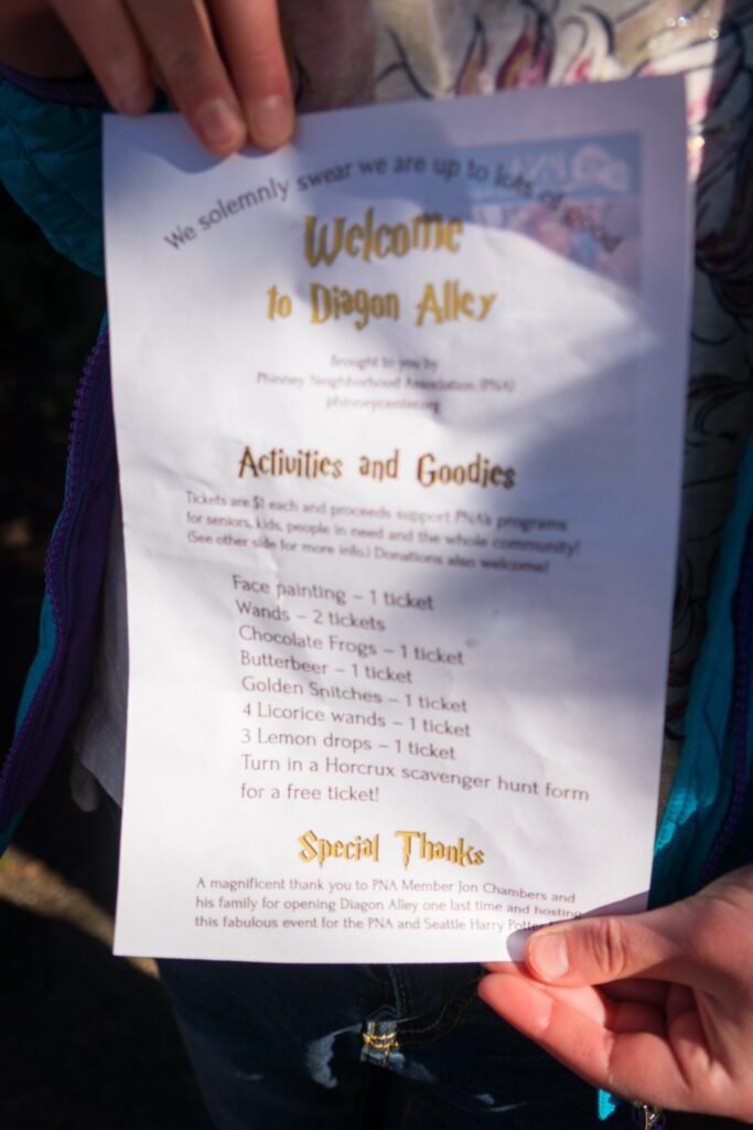 A hand holds a welcome paper listing activities and goodies for Dignan Alley.