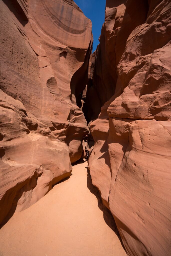 Explore the captivating beauty of slot canyons with deep red rock walls filtering sunlight.