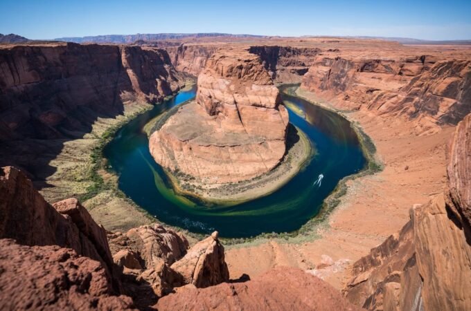 A panoramic view of Horseshoe Bend showing the river carving a dramatic curve through the desert canyon.