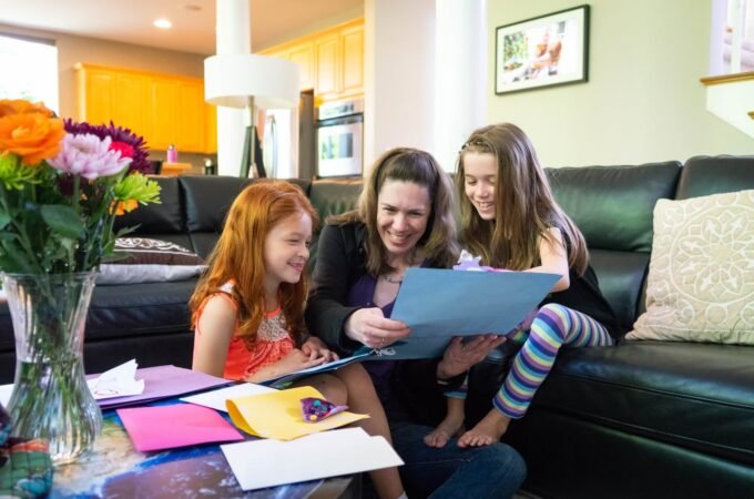 A family enjoys a creative activity together in a cozy living room, surrounded by vibrant flowers and warm lighting.