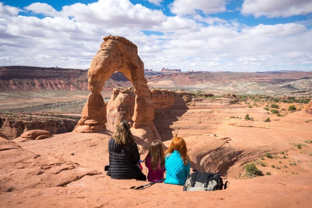 A view from the vantage point of Discovery Point in Arches National Park shows the famous Landscape Arch against a backdrop of the desert and sky.