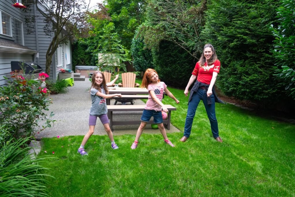 Children playing hopscotch on a backyard lawn in the Pacific Northwest.