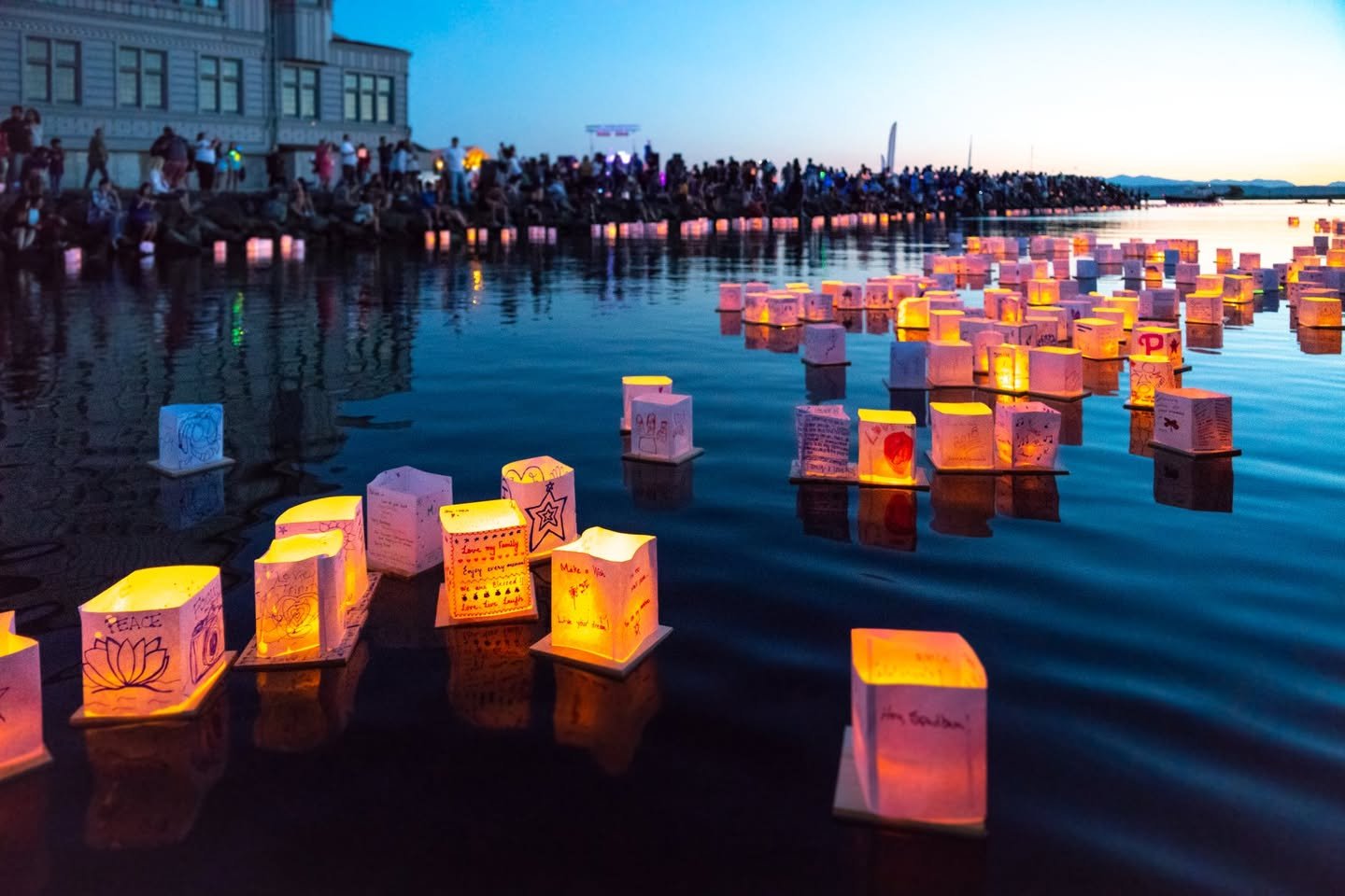 Water Lantern Festival Glowing cube-shaped lanterns float on the water during an evening festival.