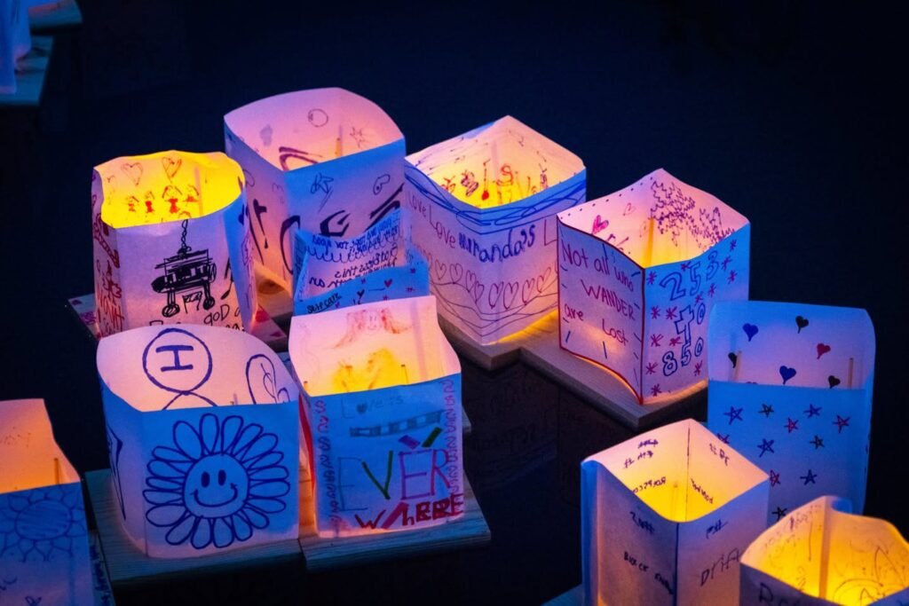 Photo of a paper light box with hand-drawn Christmas card messages and a smiling sun design.