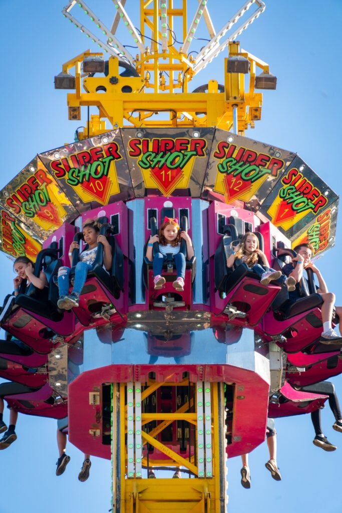 Exciting view from the Super Shot ride at an amusement park against a blue sky.