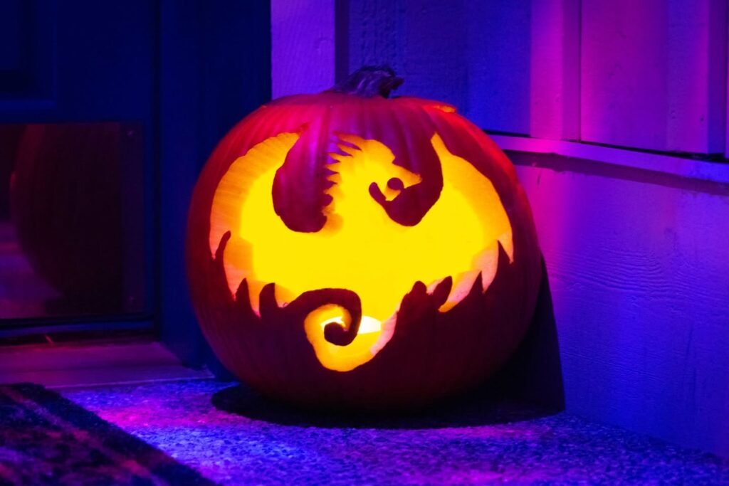 A carved pumpkin glowing yellow against a purple and blue background.