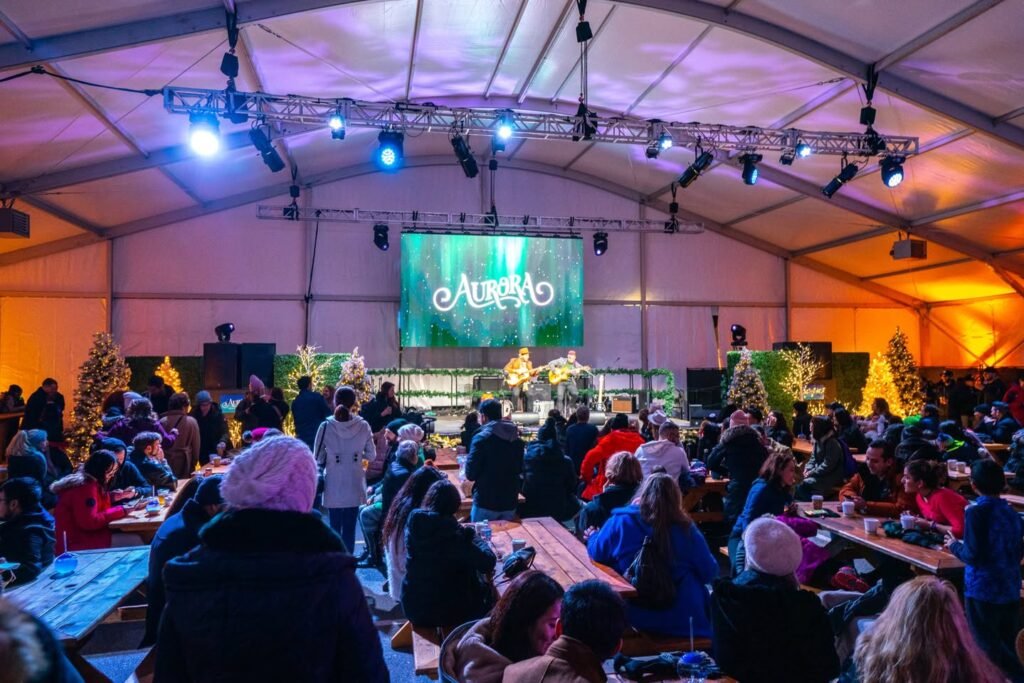 Attendees seated inside a large event tent with vibrant lighting and an AURELIO banner.