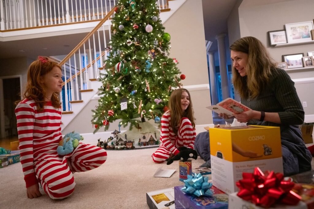 A family gathers around a Christmas tree to open presents in a cozy living room.