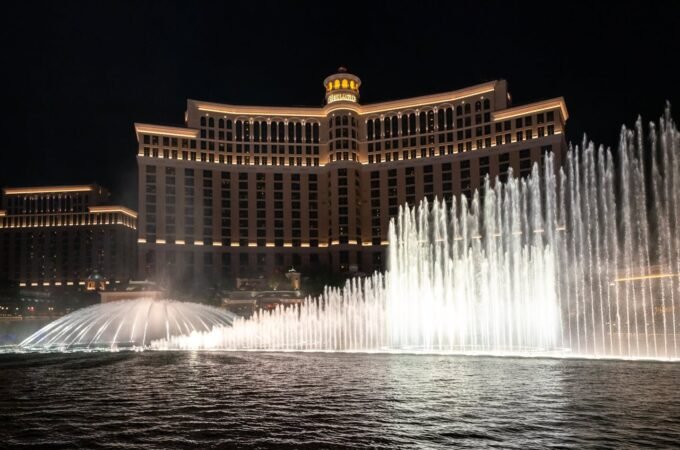 The famous Bellagio fountains dancing in front of the illuminated hotel at night.