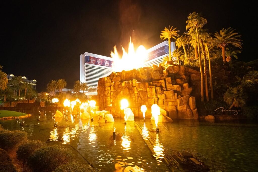 A nighttime view of the Hotel del Sol with fire effects and water features.