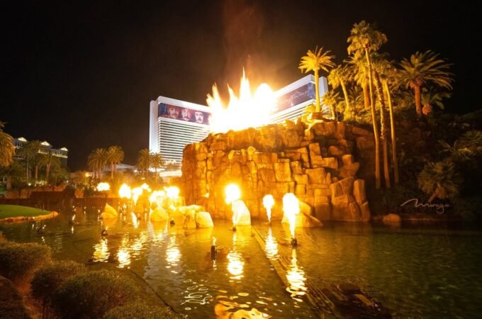 A nighttime view of the Hotel del Sol with fire effects and water features.