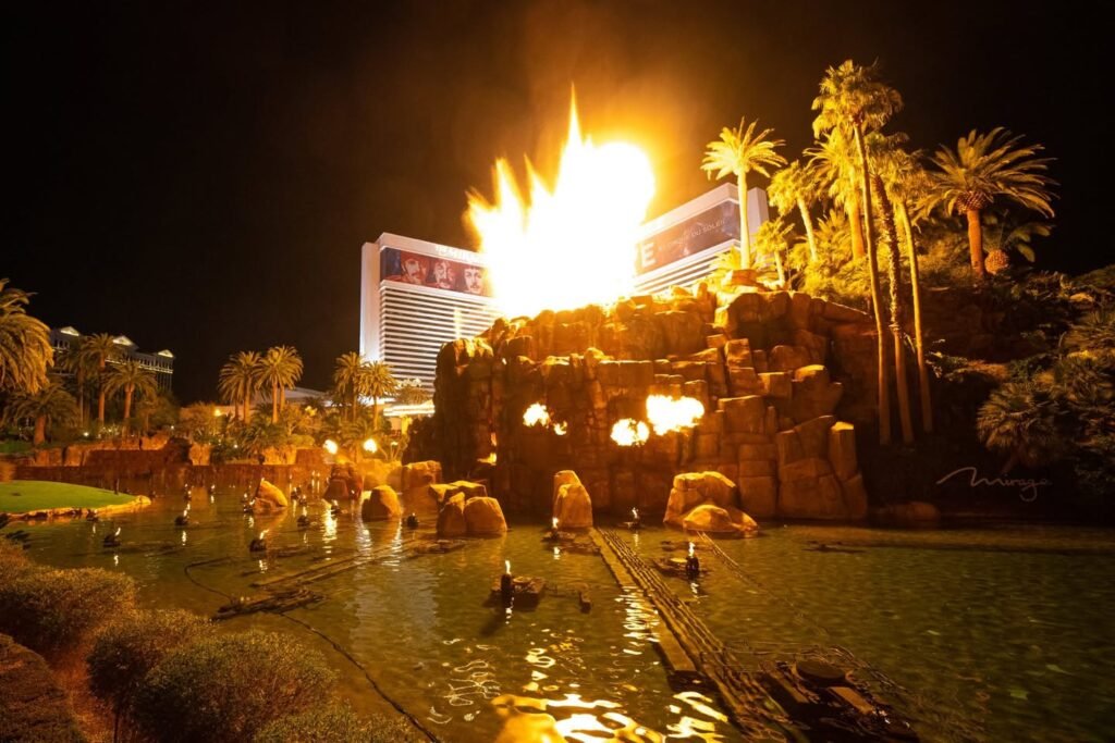 A dramatic nighttime fire show performance with a large fireball.