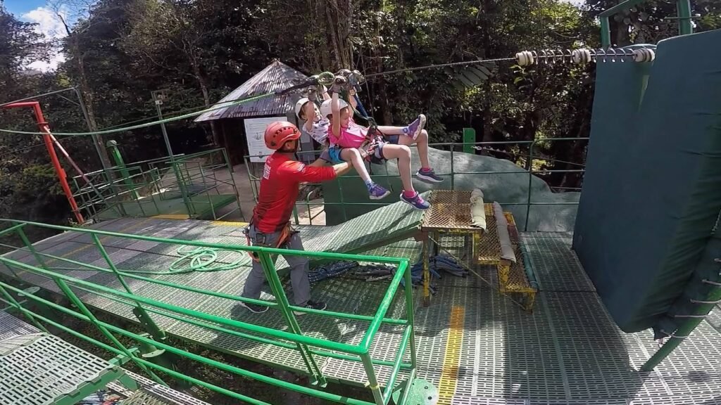 Safety crew helps prepare jumper for an aerial bungee jump at an outdoor adventure park.