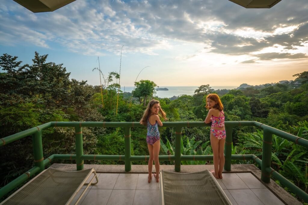 A scenic view of the ocean and jungle from a tropical viewing deck. Children enjoy the view from the zipline landing area.