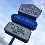 Paddle Boarding at Night A white and orange White Castle sign against a blue sky with text offering a slider deal.