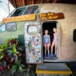 Stoppers stand in the doorway of El Avion, a distinctive airplane pub bar surrounded by tropical plants.