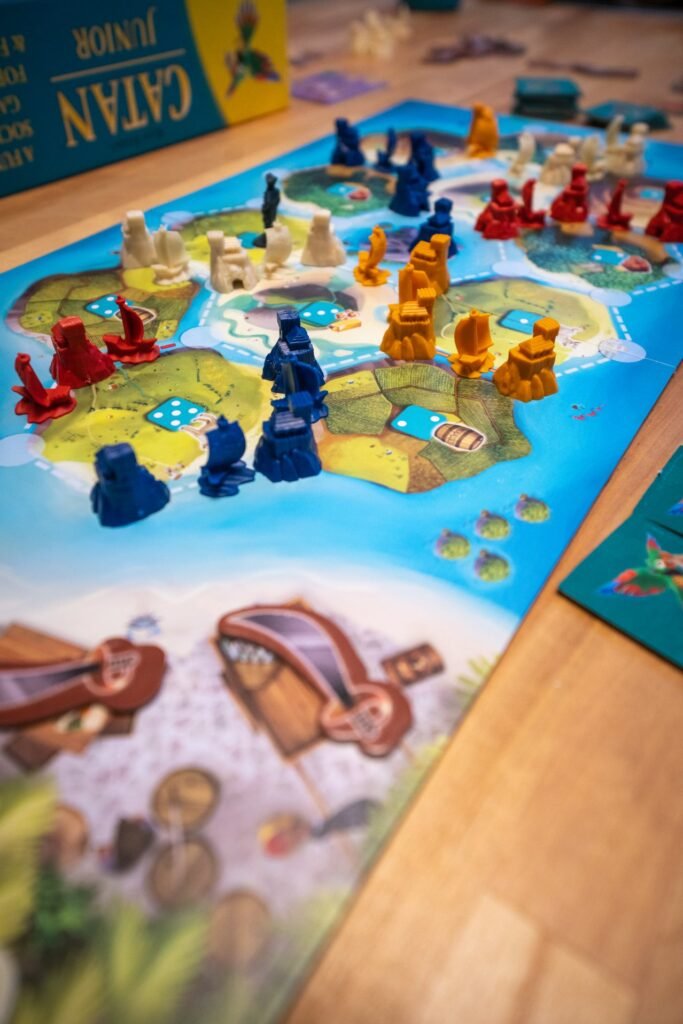 A tabletop view of the Catan board game with colored pieces ready for a game.