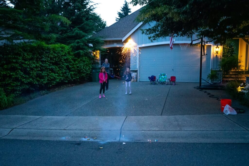 A dusk photo of a home driveway with family members, capturing the cozy atmosphere of the Pacific Northwest.