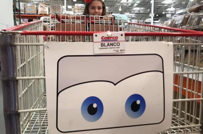 A Cortez basket with a cartoon face featuring blue eyes, with a person looking over the side in a warehouse setting.
