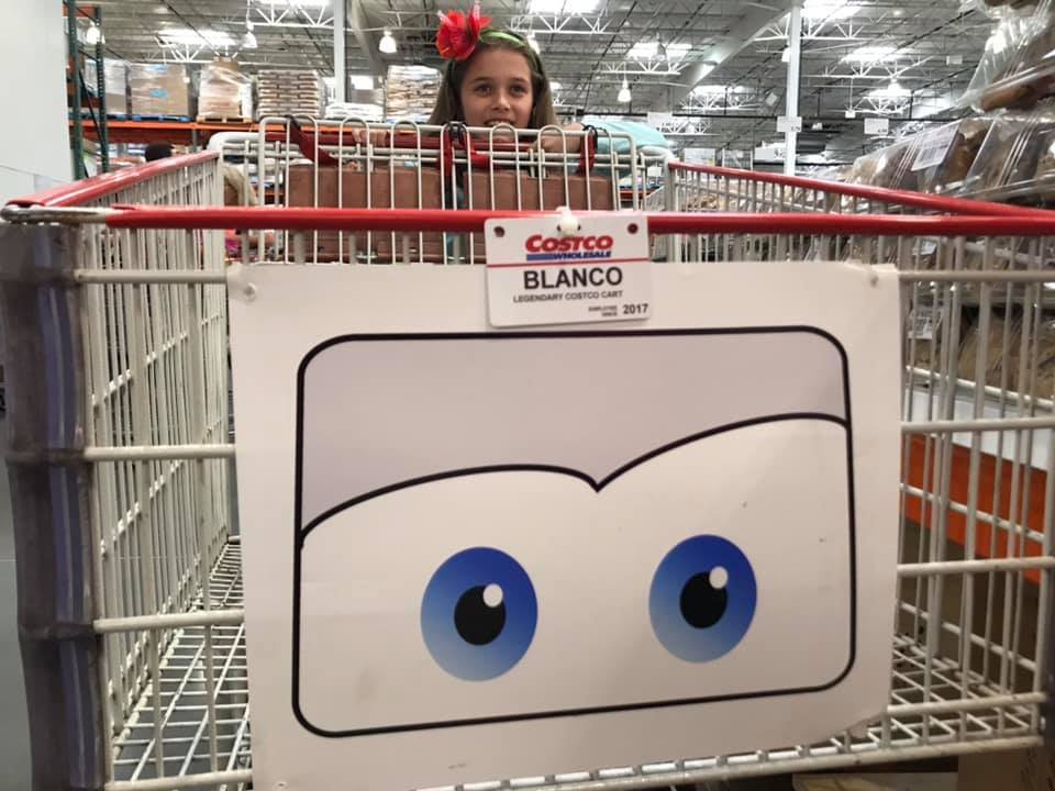 A Cortez basket with a cartoon face featuring blue eyes, with a person looking over the side in a warehouse setting.