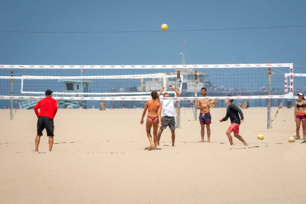 People are playing beach volleyball on a sunny day