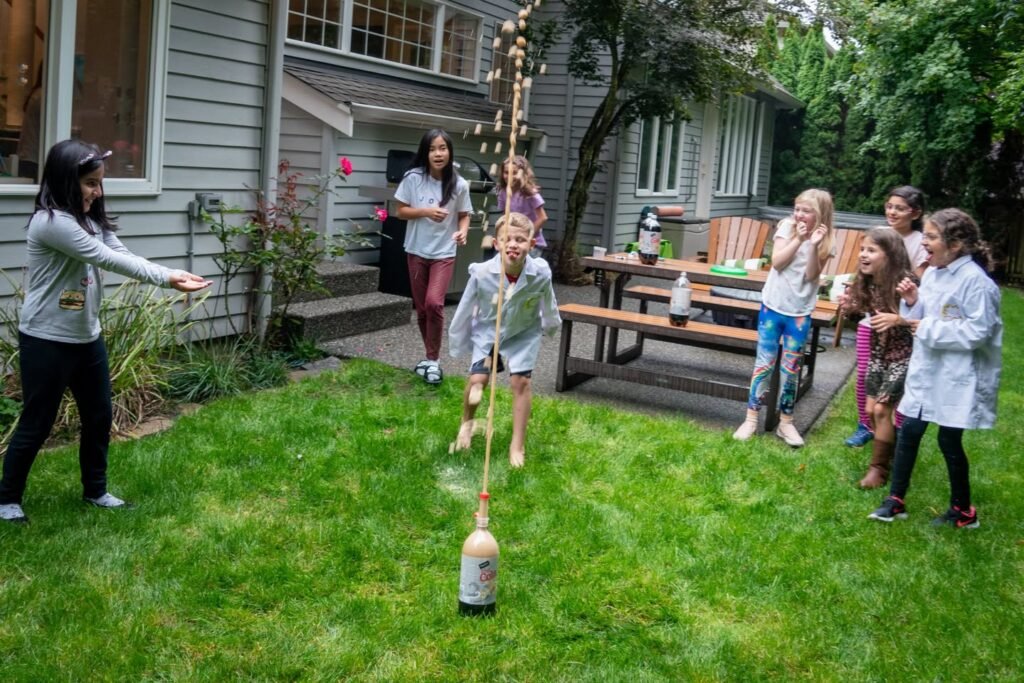 A group enjoying a backyard gathering with a bottle toss game on the grass.