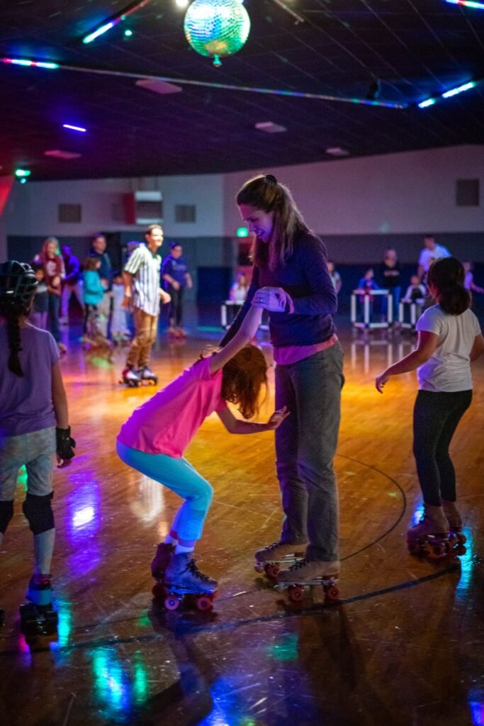 People enjoy roller skating under vibrant neon lights in a social setting.
