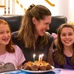 Alicorn Team Pictures A family enjoys a birthday celebration with a cake and candles in a cozy home setting.