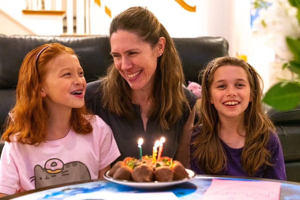 A family enjoys a birthday celebration with a cake, capturing joyful moments together.