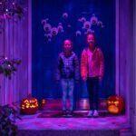 Junior Chefs A festive front porch decorated for Halloween with glowing purple lights.