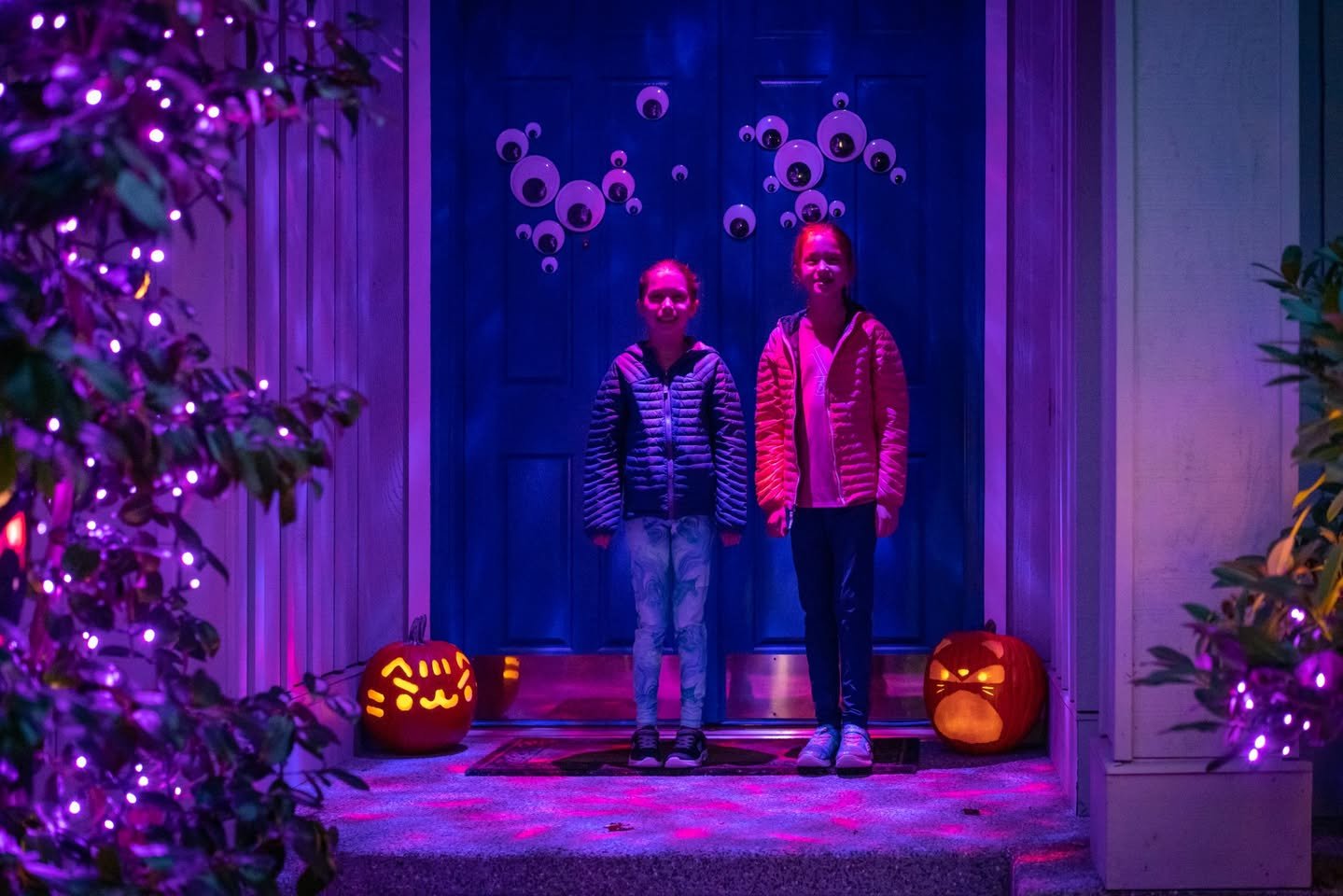 Jack-O’-Lanterns A festive front porch decorated for Halloween with glowing purple lights.