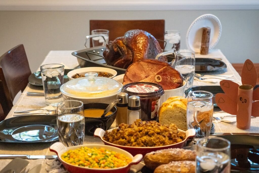 A table laden with festive holiday dishes, featuring a roasted turkey and gravy, set for a family celebration.