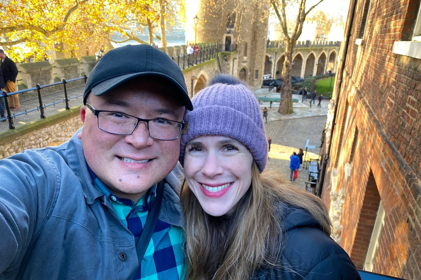 London Highlights A cheerful selfie taken near a historic brick building and arches on a sunny autumn day.
