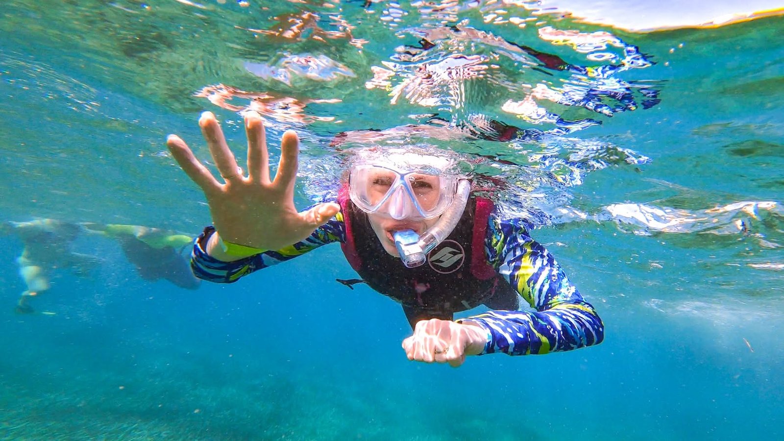 Belize Day 3 An underwater snapshot of someone skin diving in clear, blue-green water while wearing snorkeling gear.