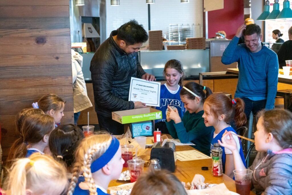An adult reads from a book to a group of children in a classroom setting.