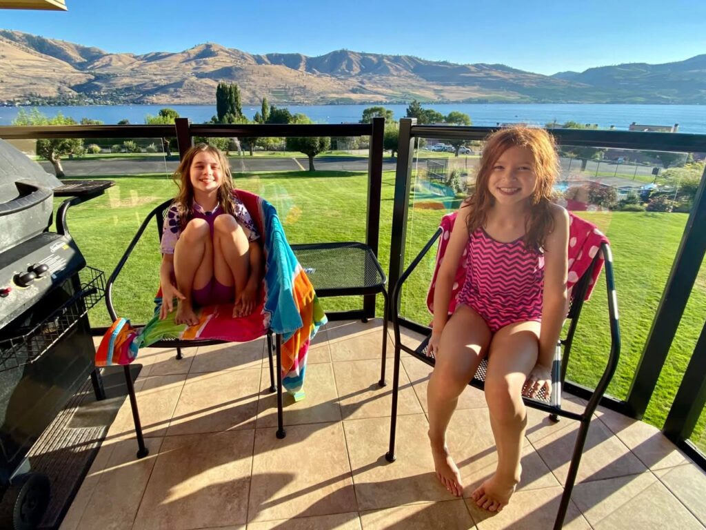 Enjoying the beautiful scenic view of a lake and mountains from a sunny patio.