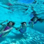 Timber A joyful underwater photo from our family vacation, capturing the vibrant blue of a crystal clear pool.
