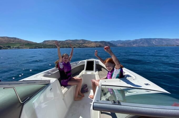 Two people are enjoying a boat ride on calm blue waters.
