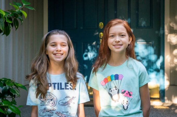 Two young girls smiling in their summer outfits. A homey photo capturing personal travel or vacation moments.