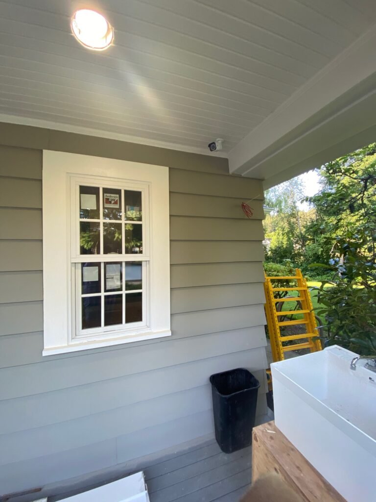 A collection of photos showing an outdoor kitchen island under construction on a porch, featuring detailed views of the ceiling lighting and window installation.