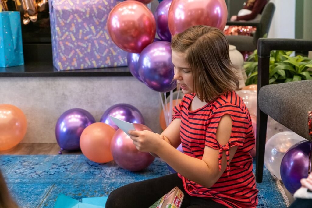 A festive scene with colorful balloons and a wrapped gift box near a table.